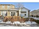 Tan two-story townhouse with a wooden fence and snow on the ground at 11565 Decatur St # 7D, Denver, CO 80234