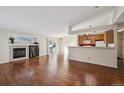 Spacious living room with hardwood floors, fireplace, and kitchen at 11565 Decatur St # 7D, Denver, CO 80234