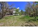 Lush backyard features mature trees, open lawn, and ample space for outdoor activities at 1673 Woodmoor Dr, Monument, CO 80132