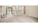 Open living space with white walls, new carpet, and an adjoining kitchen area with white cabinets and modern appliances at 3205 Moorhead Ave, Boulder, CO 80305