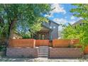 Attractive two-story home with a wooden fence and meticulous stone work in the landscaping at 3770 Osceola St, Denver, CO 80212