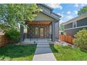 Inviting two-story home featuring a covered front porch and manicured lawn at 3770 Osceola St, Denver, CO 80212