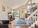 Bright living room with a brick fireplace, wooden floors, and sliding glass doors to the deck at 745 Stowe St, Highlands Ranch, CO 80126
