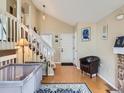 Inviting living room with wood floors, a brick fireplace, and a staircase at 745 Stowe St, Highlands Ranch, CO 80126
