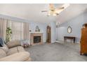 A well-lit living room featuring a brick fireplace and an overhead ceiling fan at 3170 S Princess Cir, Broomfield, CO 80020