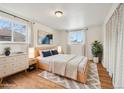 Sunlit bedroom with hardwood floors, modern decor, and two windows for natural light at 10 Merideth Ln, Longmont, CO 80501