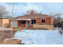 A well-maintained brick home with snowy front yard and tidy landscaping, providing curb appeal at 950 Jasmine St, Denver, CO 80220