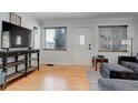 Bright living room with light hardwood floors, front door, and large windows offering natural light at 950 Jasmine St, Denver, CO 80220