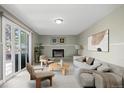 Cozy living room with a fireplace, neutral tones, and sliding glass doors at 5455 E Iowa Ave, Denver, CO 80222
