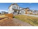 Charming two-story home with a manicured lawn and a three car garage at 806 Flora View Dr, Erie, CO 80516