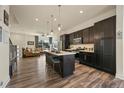 Modern kitchen boasts dark cabinets, a large island, stainless steel appliances and wood floors at 5188 Ward Rd, Wheat Ridge, CO 80033