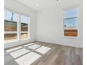 Bright bedroom features hardwood floors and large windows providing ample natural light at 11493 E Briarwood Cir, Centennial, CO 80112
