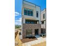 Stylish three-story townhome boasting a brick base, modern design, and an inviting entrance at 11493 E Briarwood Cir, Centennial, CO 80112