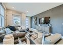 Stylishly designed living room with a large sectional sofa and modern decor at 6877 Bryant Ct, Denver, CO 80221