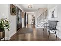 Welcoming entryway featuring hardwood floors, modern light fixture, and an eye-catching staircase with metal railings at 7152 E Hinsdale Pl, Centennial, CO 80112