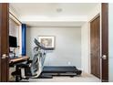 Neutral toned room with a treadmill, desk, and a window letting in natural light at 907 E 22Nd Ave, Denver, CO 80205