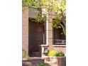 Brick townhome featuring an inviting front porch with a house number and a mailbox at 907 E 22Nd Ave, Denver, CO 80205