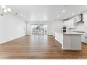 Sunlit living room featuring wood floors, sliding glass doors, and open concept kitchen at 16478 W 92Nd Pl, Arvada, CO 80007
