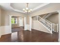 Elegant foyer showcasing dark wood floors, decorative pillars, and a staircase with white railings at 1339 Sidewinder Cir, Castle Rock, CO 80108