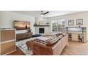 Bright living room featuring a brick fireplace, ceiling fan, and a large window at 24356 E Powers Ave, Aurora, CO 80016