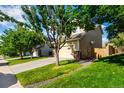 Side view of a beige two-story home with a two car garage, grass, and blue skies at 5972 S Zante Way, Aurora, CO 80015
