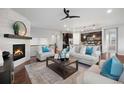 Comfortable living room open to kitchen with a fireplace, ceiling fan, and hardwood floors at 10049 Isle St, Parker, CO 80134