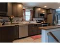 Modern kitchen features stainless steel appliances, dark cabinets, white subway tile, and light countertops at 1134 Del Mar Pkwy, Aurora, CO 80010