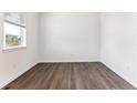 Bright bedroom with window and wood-look floors, offering a clean and minimalist aesthetic at 4115 Marble Dr, Mead, CO 80504