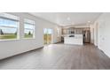 Bright living room and kitchen featuring hard wood floors, modern appliances, and sliding door to backyard at 4115 Marble Dr, Mead, CO 80504
