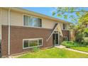 Brick and siding home with a well-manicured lawn and covered entryway at 6484 Kendall St, Arvada, CO 80003