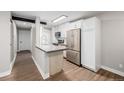 Bright kitchen featuring stainless steel appliances, white cabinets, and a modern island with breakfast bar at 230 E Highline Cir # 101, Centennial, CO 80122