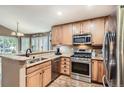 Well-lit kitchen features stainless steel appliances, granite countertops, wood cabinets and hardwood floors at 16200 Hedgeway Dr, Parker, CO 80134