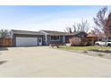 Well-maintained home featuring a landscaped front yard, garage, large driveway, and appealing curb appeal at 4833 S Elati St, Englewood, CO 80110