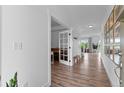 Bright hallway with hardwood floors, white trim, and doorways leading to other rooms of the home at 601 Morrison Dr, Frederick, CO 80530