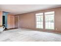 Bright living room with carpet floors, two windows, and a view to the door to the bedroom at 7300 Beech St, Arvada, CO 80005