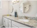 Bright bathroom with double sinks, granite countertops, and decorative mirrors at 4715 Garland St, Wheat Ridge, CO 80033