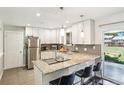 Modern kitchen with white cabinets, granite countertops, stainless steel appliances, and breakfast bar seating at 4715 Garland St, Wheat Ridge, CO 80033