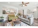 Comfortable living room featuring a ceiling fan, dark laminate flooring, and an opening into the kitchen at 4715 Garland St, Wheat Ridge, CO 80033
