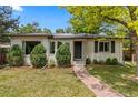 Inviting home showcasing a neatly landscaped yard, stone pathway, and solar panels, enhancing curb appeal at 3209 E Yale Way, Denver, CO 80210