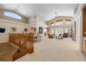 Open-concept living room with high ceilings, large windows, and staircase leading to another level at 17 Canon Dr, Greenwood Village, CO 80111