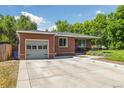Attractive brick home with a driveway, one-car garage, and manicured front yard at 7350 W 21St Ave, Lakewood, CO 80214