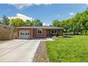 A well-maintained brick house with a green lawn, garage, and inviting front entrance at 7350 W 21St Ave, Lakewood, CO 80214