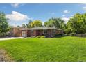 A beautiful brick house with an expansive lawn, mature trees, and an attached garage at 7350 W 21St Ave, Lakewood, CO 80214