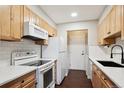 Bright kitchen features wooden cabinets, and white appliances at 7705 W 87Th Dr, Arvada, CO 80005