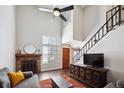 Bright living room featuring a fireplace, tall windows, and an open staircase at 7705 W 87Th Dr, Arvada, CO 80005
