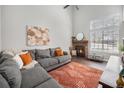 Bright living room with fireplace, hardwood floors, and large windows for natural light at 7705 W 87Th Dr, Arvada, CO 80005