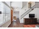 Bright living room featuring a dining area, tall windows, and an open staircase at 7705 W 87Th Dr, Arvada, CO 80005