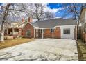 Charming brick home featuring a covered entrance and a long concrete driveway, ideal for a Gathering at 1448 Newport St, Denver, CO 80220