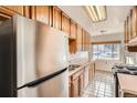 Kitchen with wood cabinets, stainless steel appliances, and tile floor at 4981 E Cornell Ave, Denver, CO 80222