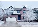 Charming two-story brick home with a well-maintained lawn and a two-car garage covered in fresh snow at 26032 E Geddes Cir, Aurora, CO 80016